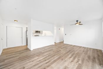 A room with a ceiling fan and a wood floor.
